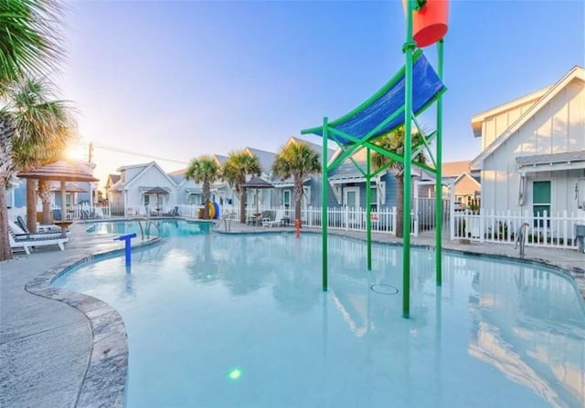 pool at dusk featuring a patio area