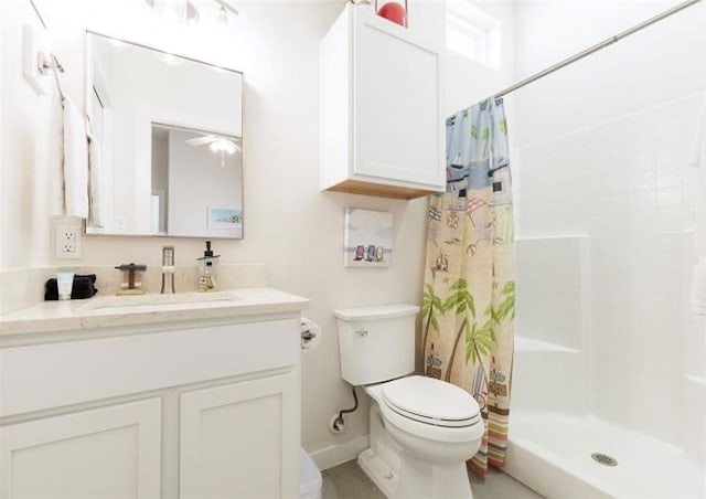 bathroom featuring curtained shower, toilet, and vanity