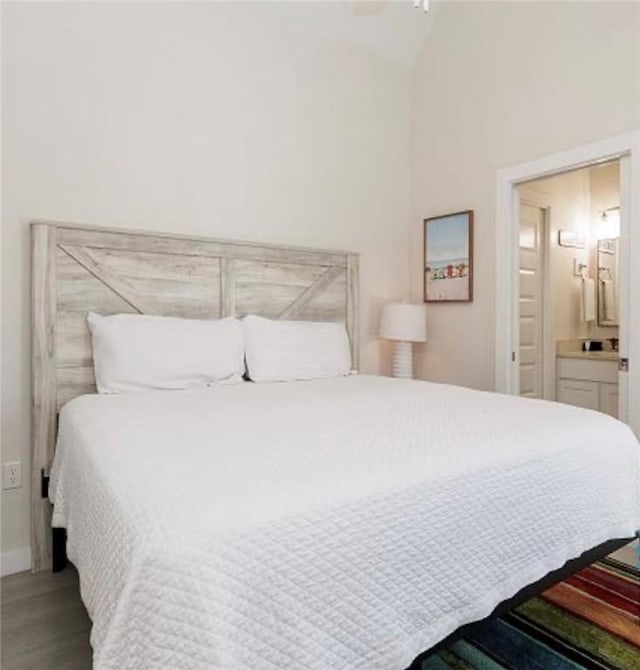 bedroom with ensuite bathroom and wood-type flooring