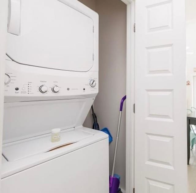 clothes washing area featuring stacked washer / dryer