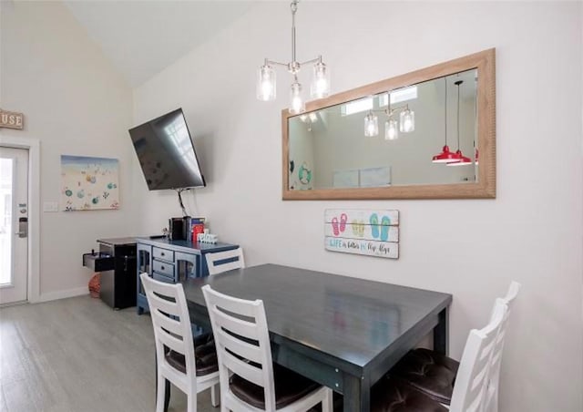 dining area featuring light hardwood / wood-style flooring and vaulted ceiling