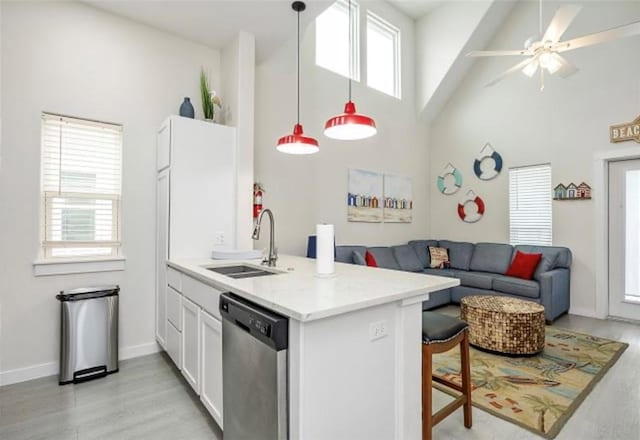 kitchen with dishwasher, sink, decorative light fixtures, white cabinets, and a healthy amount of sunlight