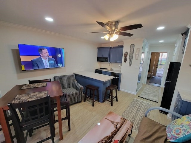 living room featuring sink, ornamental molding, ceiling fan, and light wood-type flooring