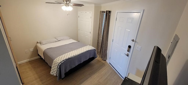 bedroom with wood-type flooring, ornamental molding, and ceiling fan