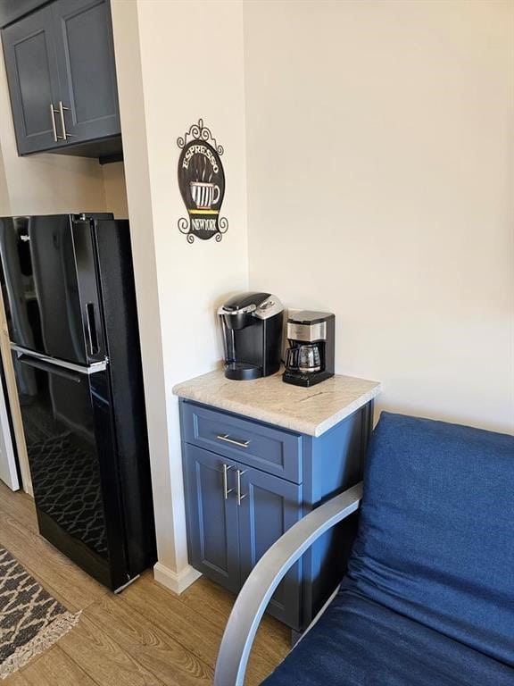 interior space featuring black fridge and light hardwood / wood-style floors