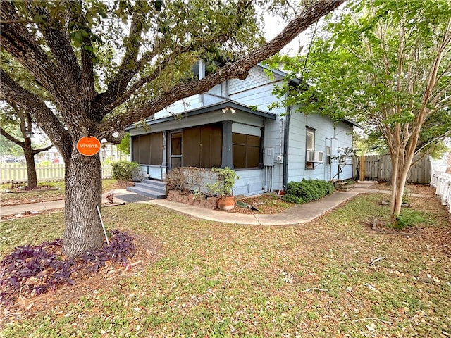 view of front of home featuring cooling unit and a front yard