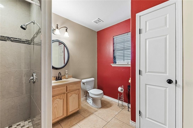 bathroom with tile patterned floors, toilet, vanity, and tiled shower