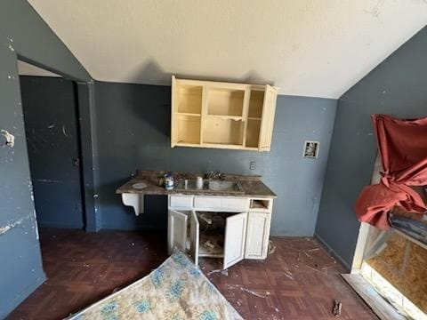 kitchen with lofted ceiling, sink, and dark parquet flooring