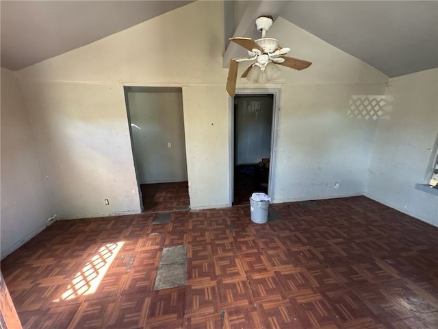 empty room with ceiling fan, dark parquet flooring, and lofted ceiling