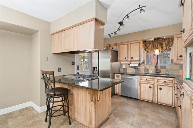 11809 Lori Dr, Corpus Christi, TX 78410 - kitchen featuring stainless steel appliances, a sink, light brown cabinetry, a peninsula, and a breakfast bar area