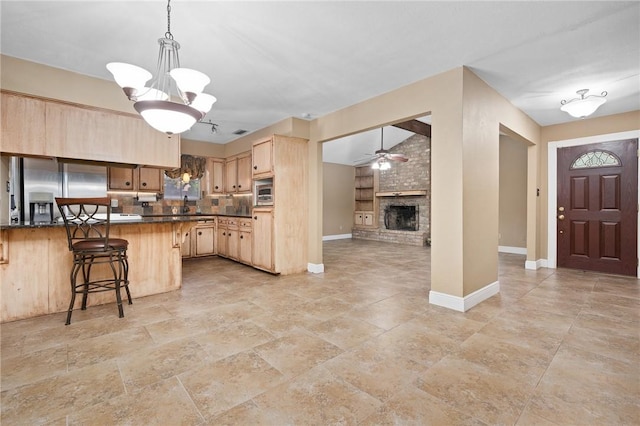 11809 Lori Dr, Corpus Christi, TX 78410 - kitchen featuring stainless steel appliances, light brown cabinetry, dark countertops, a kitchen breakfast bar, and baseboards