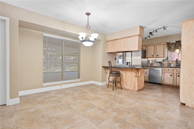 11809 Lori Dr, Corpus Christi, TX 78410 - kitchen featuring stainless steel appliances, light brown cabinets, dark countertops, baseboards, and a peninsula