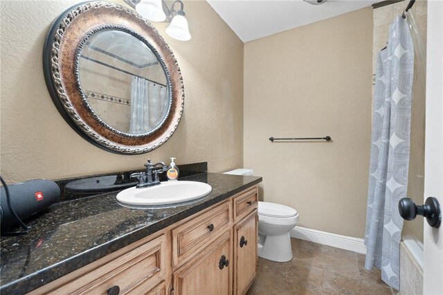 11809 Lori Dr, Corpus Christi, TX 78410 - bathroom featuring vanity, toilet, a textured wall, curtained shower, and baseboards
