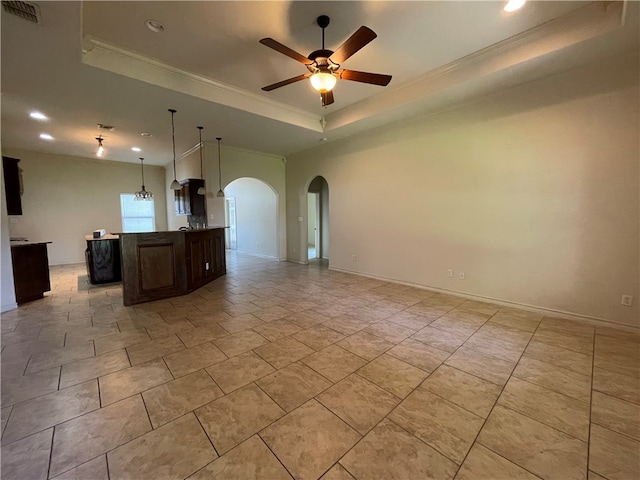 spare room featuring ceiling fan with notable chandelier, crown molding, and a tray ceiling