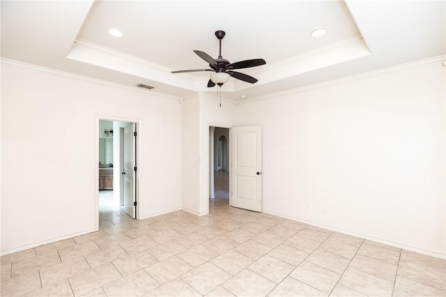 spare room featuring a tray ceiling, a ceiling fan, and crown molding