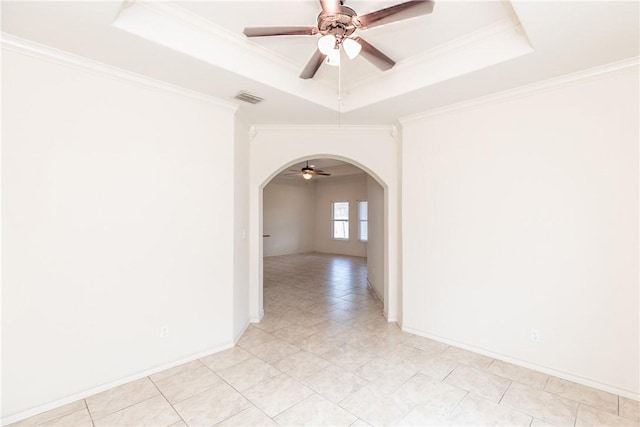 empty room with visible vents, arched walkways, a raised ceiling, and a ceiling fan