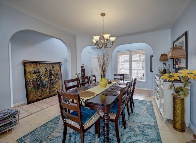 13810 Eaglesnest Bay Dr, Corpus Christi, TX 78418 - dining room featuring arched walkways, a chandelier, light tile patterned flooring, and baseboards