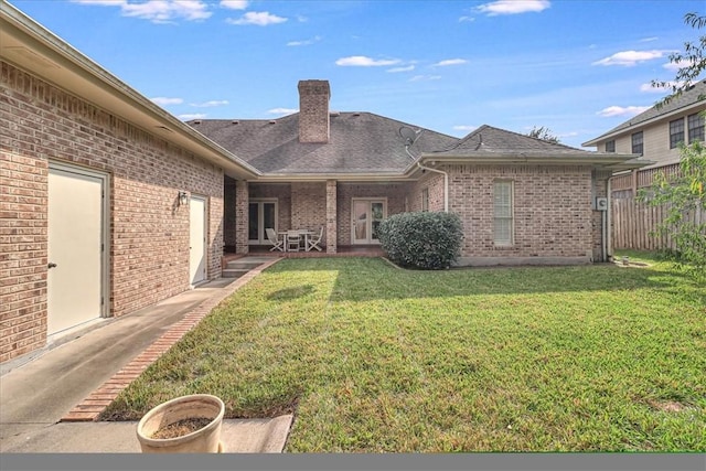 4217 Spring Creek Dr, Corpus Christi, TX 78410 - back of property with fence, a chimney, brick siding, a patio area, and a yard