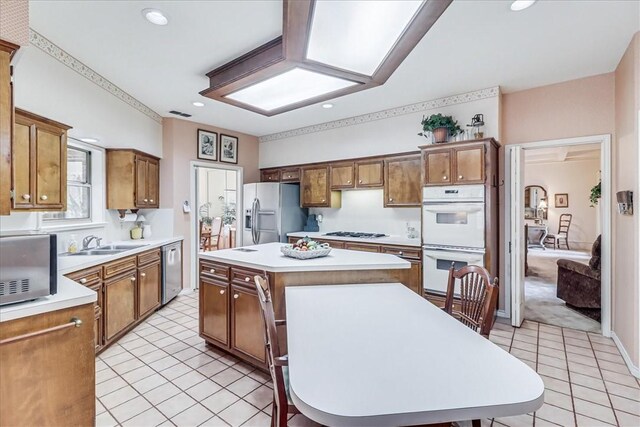 4217 Spring Creek Dr, Corpus Christi, TX 78410 - kitchen with a kitchen island, stainless steel dishwasher, white double oven, a sink, and refrigerator with ice dispenser