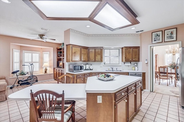 4217 Spring Creek Dr, Corpus Christi, TX 78410 - kitchen with brown cabinetry, appliances with stainless steel finishes, a sink, light countertops, and open floor plan
