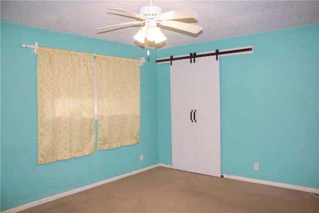33 Encino Loma, Beeville, TX 78102 - unfurnished bedroom featuring a textured ceiling, carpet, a closet, a barn door, and a ceiling fan
