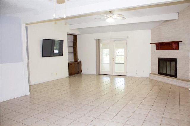 33 Encino Loma, Beeville, TX 78102 - unfurnished living room featuring beam ceiling, ceiling fan, french doors, a brick fireplace, and light tile patterned flooring