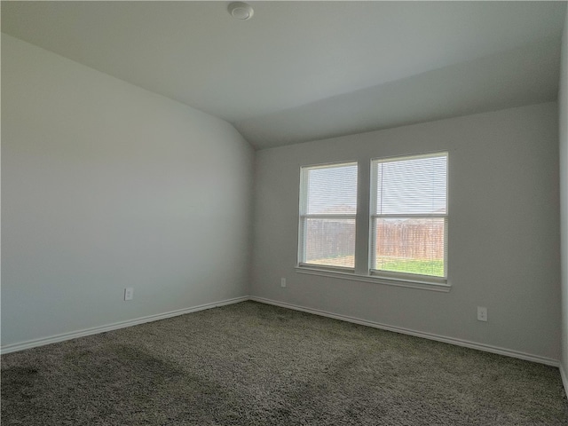 carpeted spare room with lofted ceiling