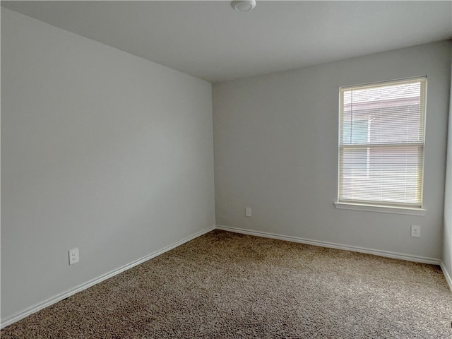 carpeted spare room featuring a healthy amount of sunlight