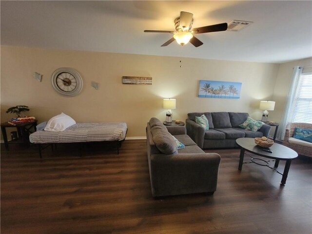 living area with visible vents, baseboards, wood finished floors, and a ceiling fan