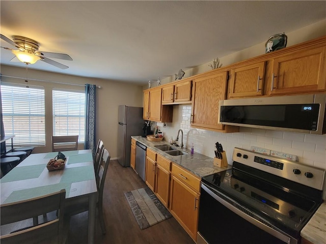 kitchen with tasteful backsplash, ceiling fan, dark wood-style floors, stainless steel appliances, and a sink