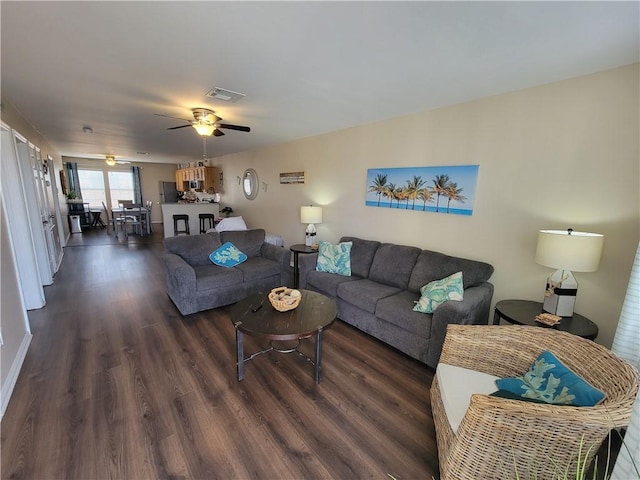 living area featuring dark wood-type flooring, a ceiling fan, and visible vents