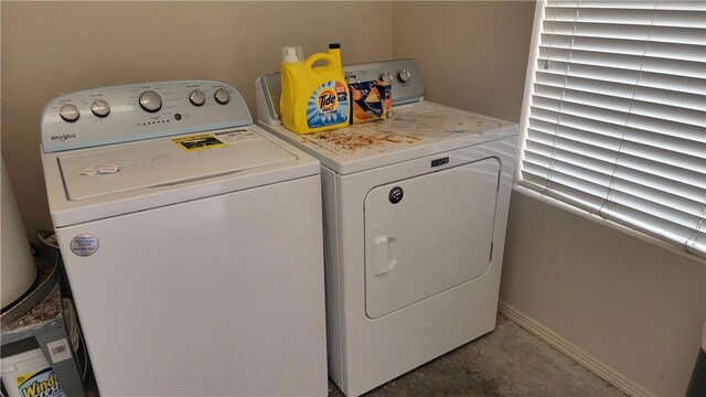 washroom featuring laundry area, washing machine and dryer, and baseboards