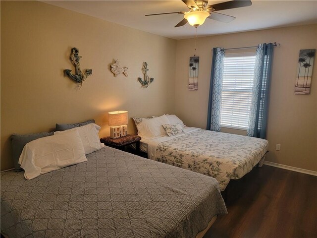 bedroom featuring a ceiling fan, dark wood-type flooring, and baseboards