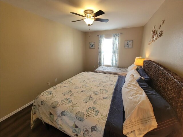 bedroom featuring a ceiling fan, dark wood-style floors, and baseboards