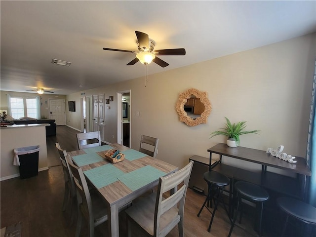 dining space with baseboards, dark wood-style floors, visible vents, and ceiling fan