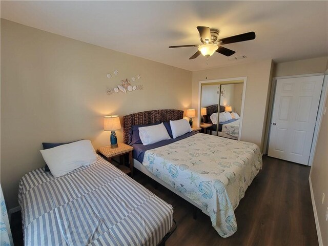 bedroom featuring a closet, dark wood-type flooring, visible vents, and a ceiling fan