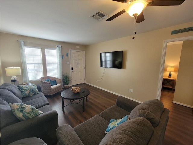 living area featuring ceiling fan, visible vents, baseboards, and wood finished floors