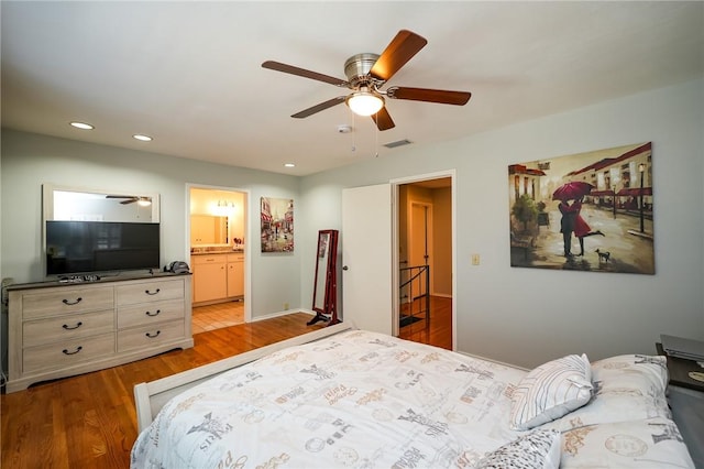 bedroom featuring ceiling fan, light wood-type flooring, and ensuite bath