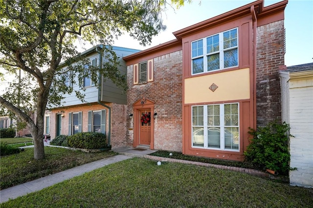 townhome / multi-family property featuring a front lawn