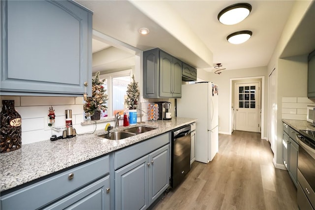 kitchen with decorative backsplash, light wood-type flooring, sink, range, and black dishwasher