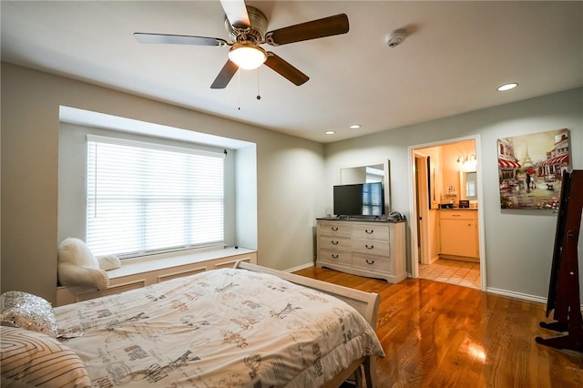 bedroom featuring wood-type flooring, ensuite bath, and ceiling fan