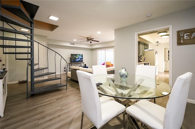 dining space with wood-type flooring and ceiling fan