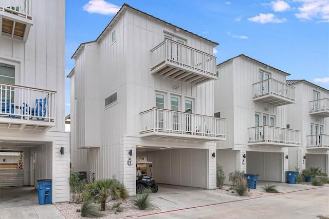 4885 S State Highway 361st St Unit H, Port Aransas, TX 78373 - view of front facade with a balcony, concrete driveway, an attached garage, and board and batten siding