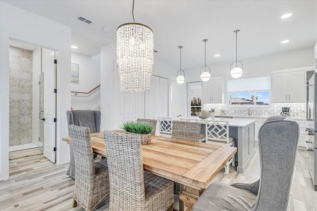 4885 S State Highway 361st St Unit H, Port Aransas, TX 78373 - dining room featuring a chandelier, light wood-style floors, recessed lighting, and stairs