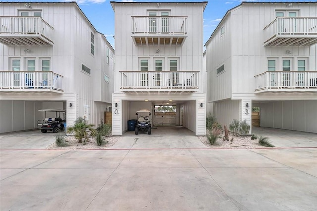 4885 S State Highway 361st St Unit H, Port Aransas, TX 78373 - view of front of house with a carport, driveway, a balcony, and board and batten siding