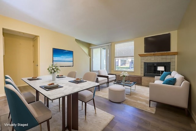 dining space with wood-type flooring and a fireplace