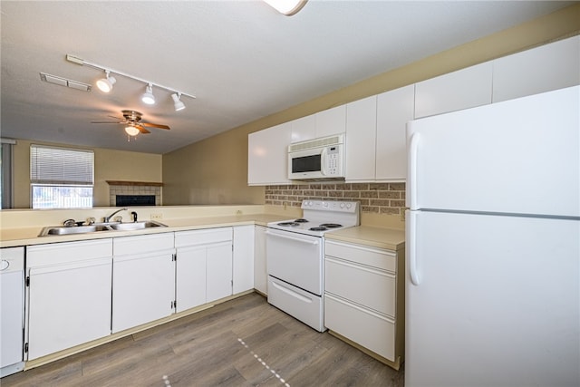 kitchen with wood-type flooring, white appliances, white cabinetry, and sink