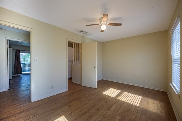 spare room with dark hardwood / wood-style flooring and ceiling fan