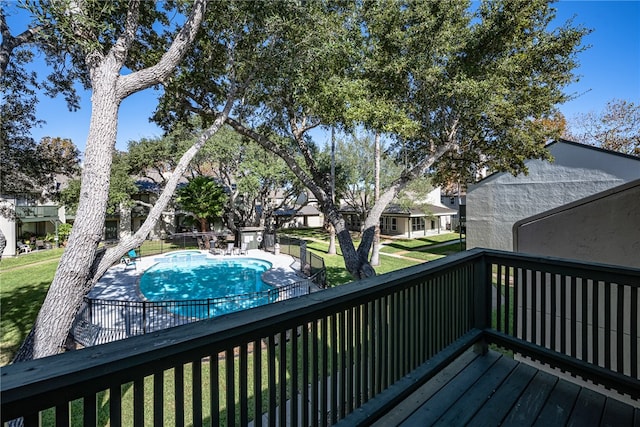 wooden terrace with a fenced in pool and a yard