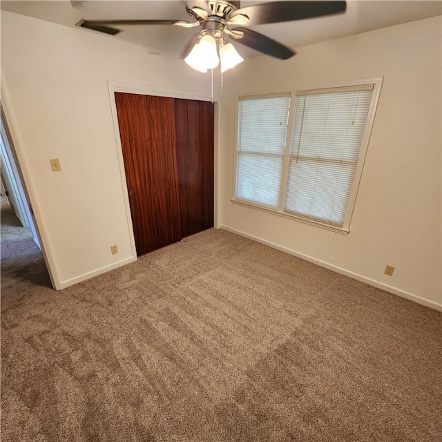 unfurnished bedroom featuring carpet flooring, ceiling fan, and a closet